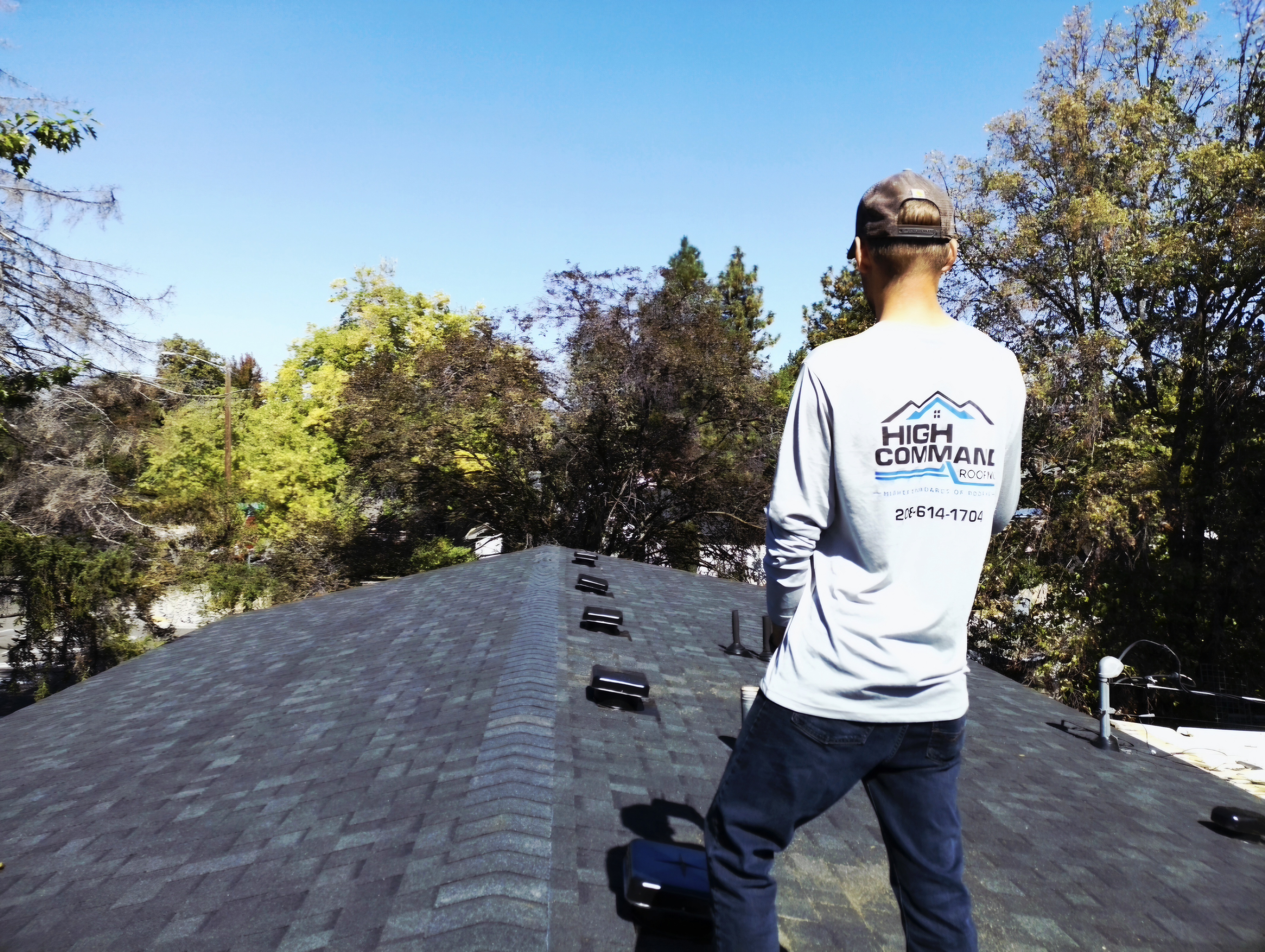 Raymond Trujillo of High Command Roofing on a roof in his High Command shirt
