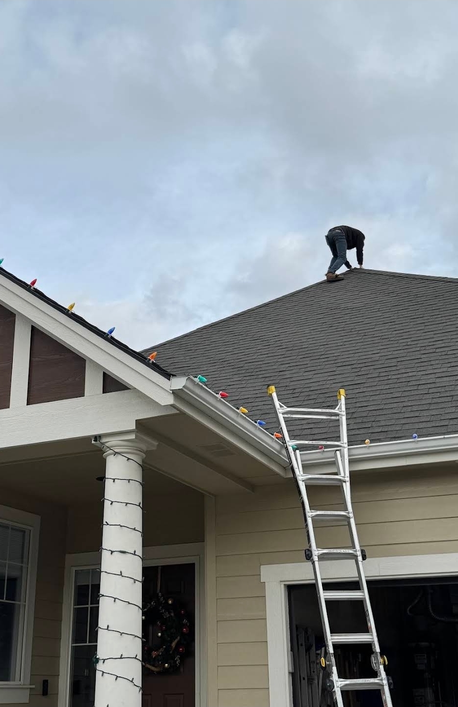 High Command Roofing installer working on the peak of a gray shingle roof in Eagle, Idaho